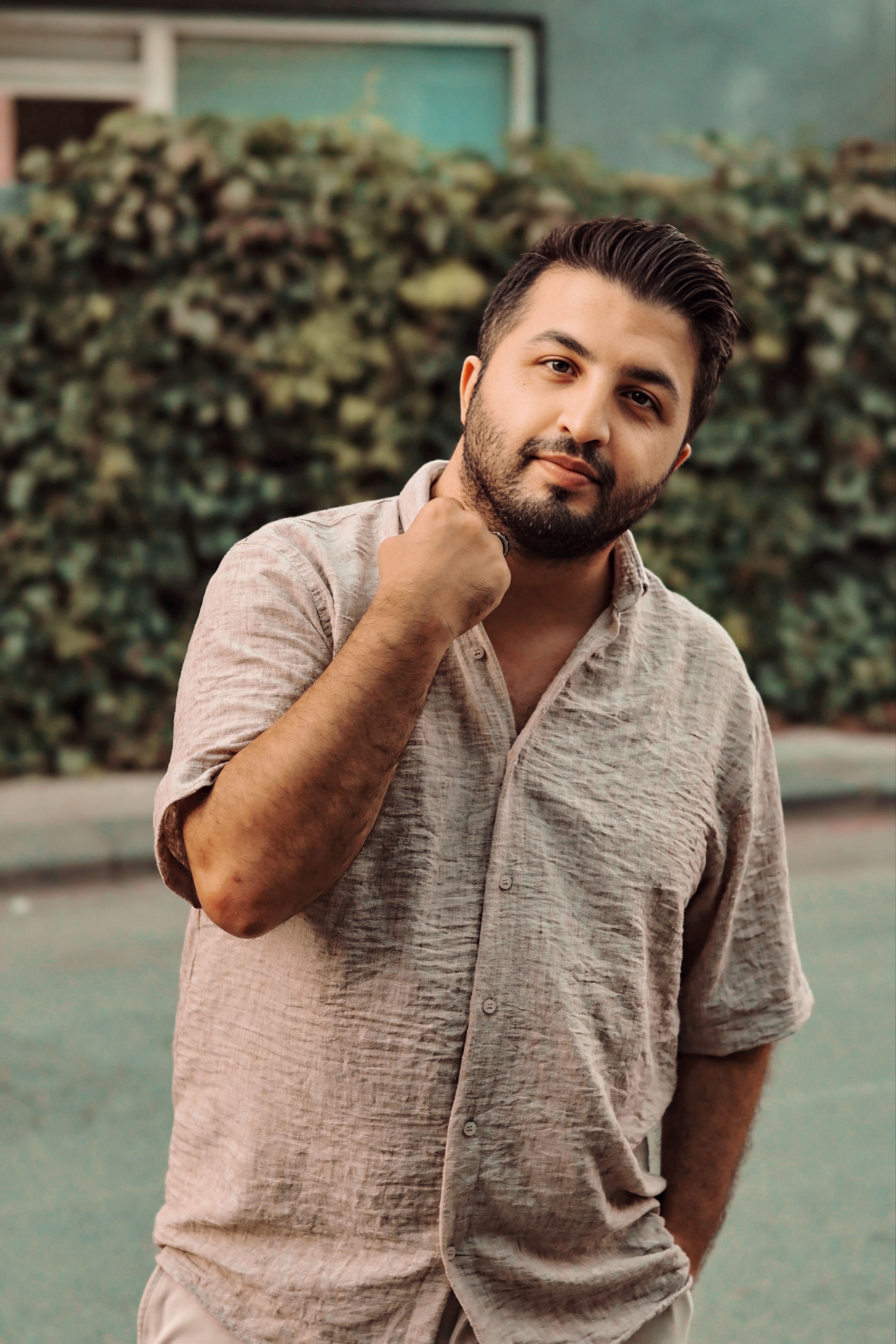 Casual portrait of a man standing outdoors, conveying a relaxed and thoughtful mood.