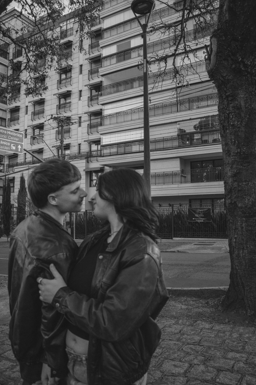 Free A couple in love embraces on an urban street with tall buildings in the background. Stock Photo