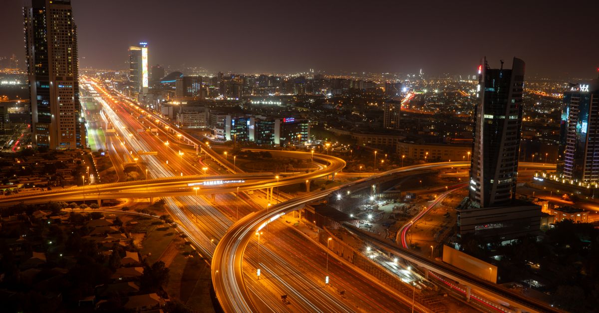 A breathtaking view of Dubai's vibrant skyline and illuminated roads at night, showcasing modern urb