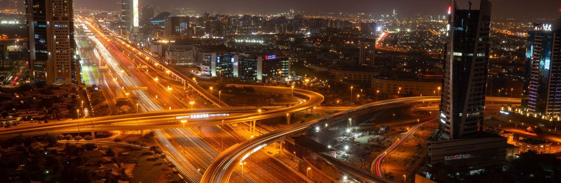 A breathtaking view of Dubai's vibrant skyline and illuminated roads at night, showcasing modern urb