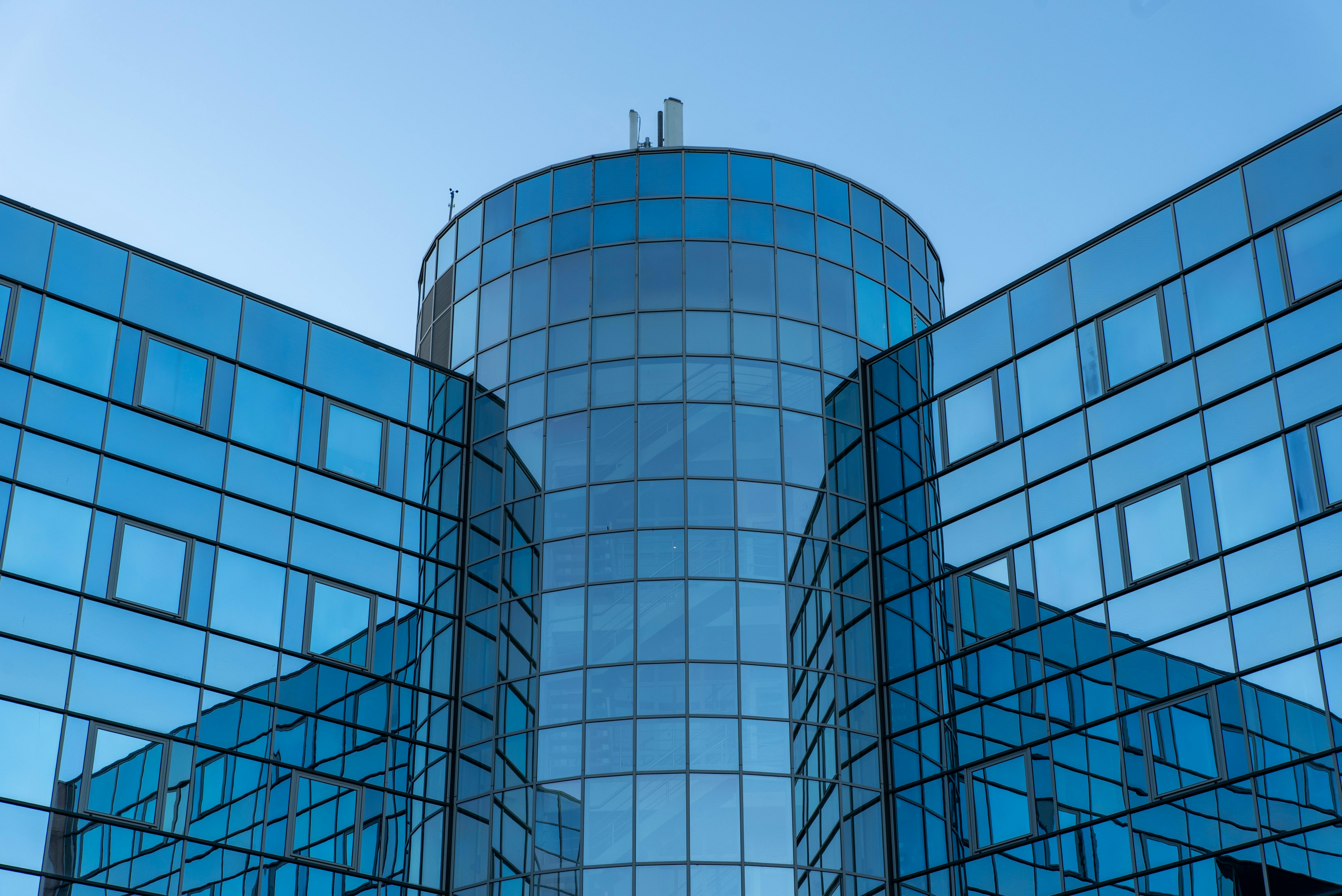 A striking architectural facade with reflective glass windows under a clear blue sky.