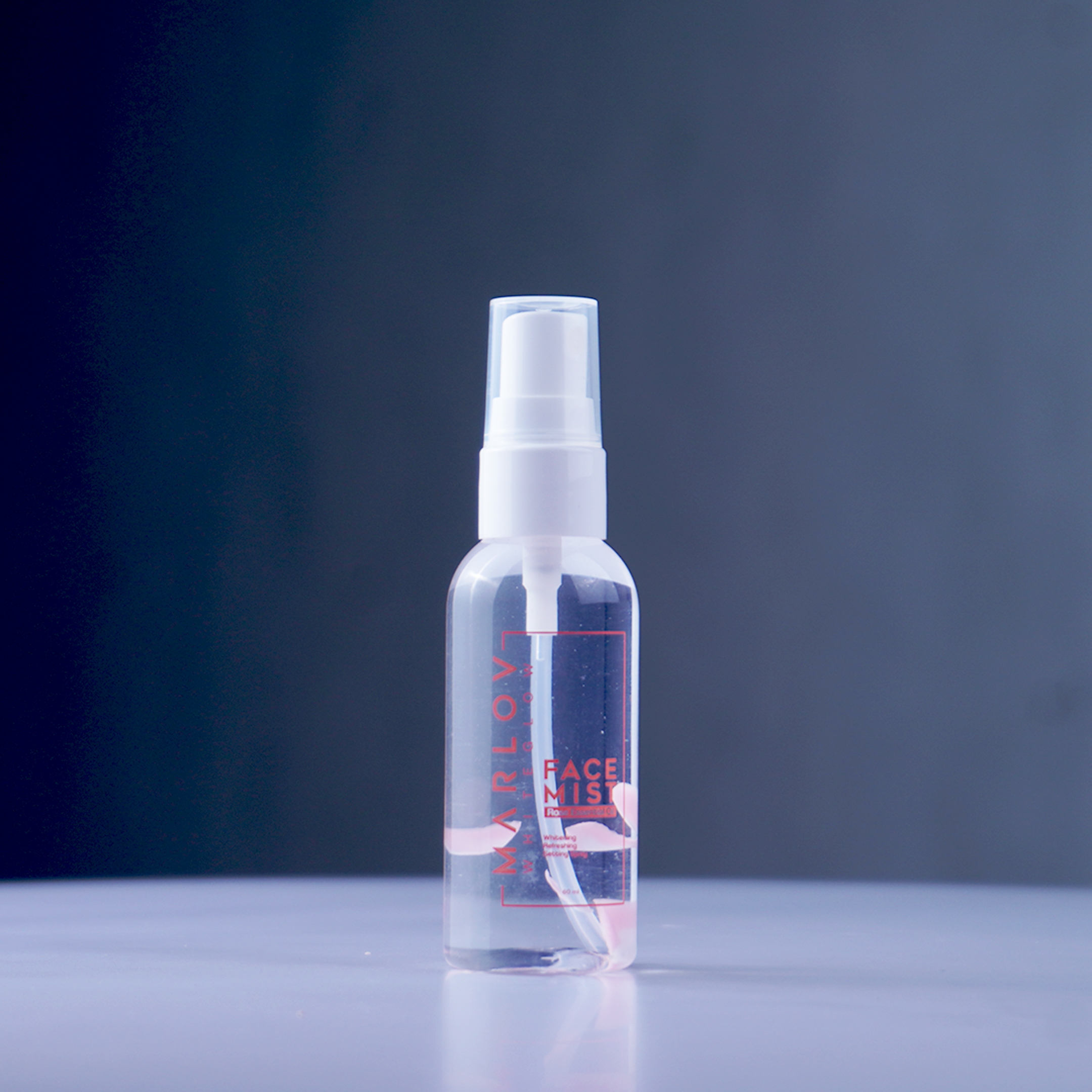 Clear skincare spray bottle on a blue background
