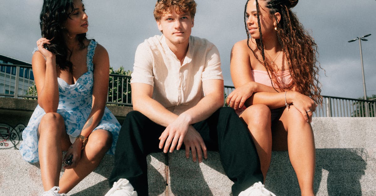 A diverse group of friends sitting on steps outdoors, enjoying a sunny day together.