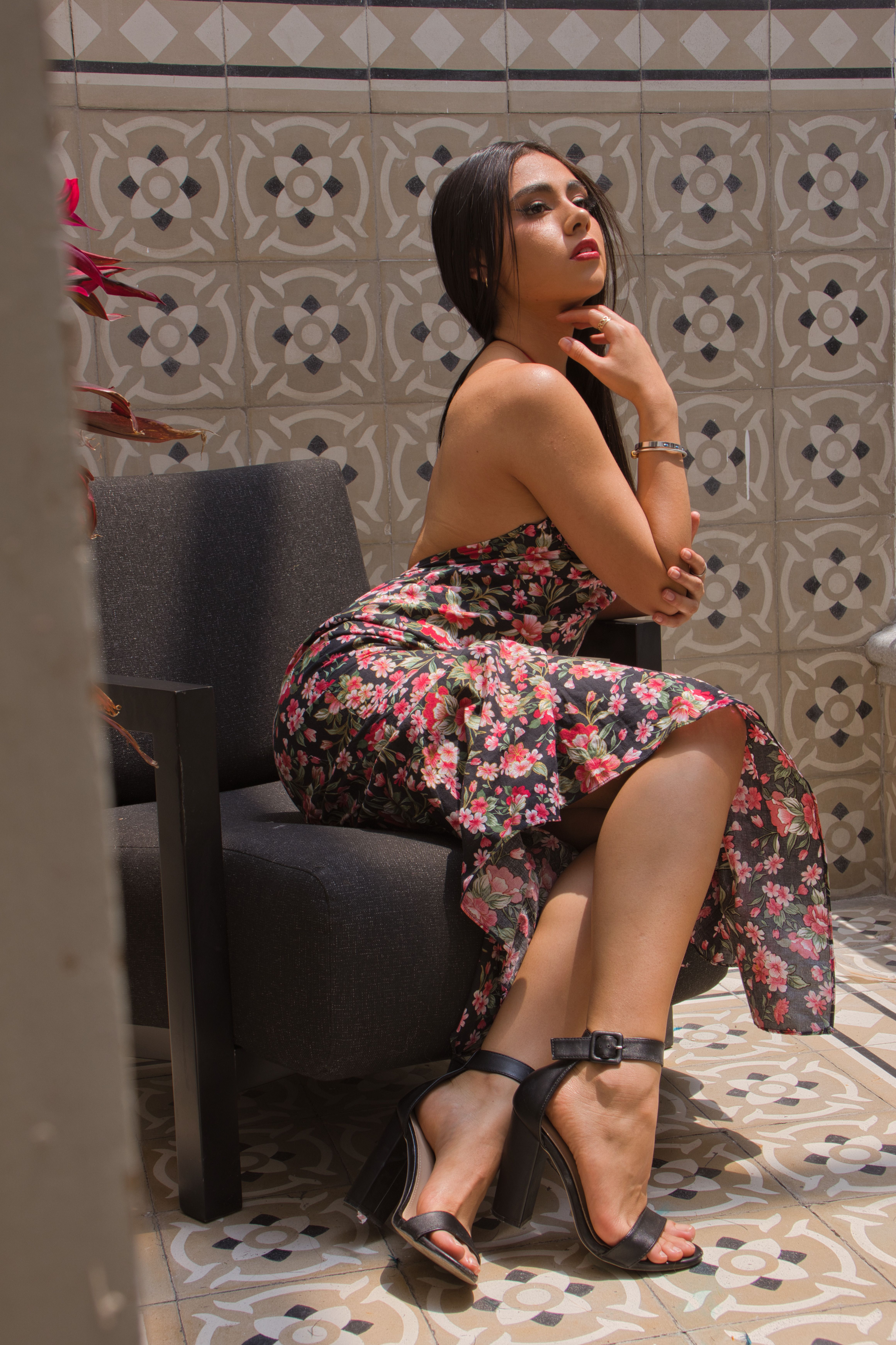 Elegant Woman in Floral Dress Seated Indoors · Free Stock Photo