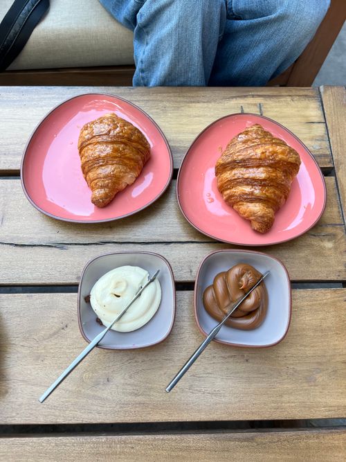 Free Two croissants with butter and dulce de leche on a wooden table in Buenos Aires. Stock Photo