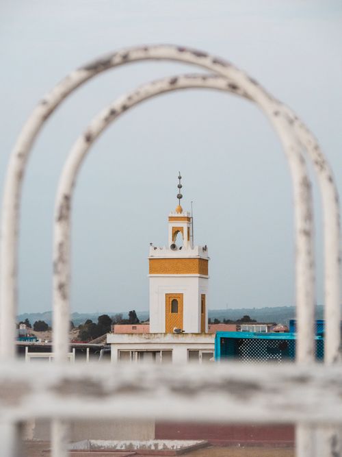 Free Beautiful view of a mosque minaret framed through an arch in Essaouira, Morocco. Stock Photo
