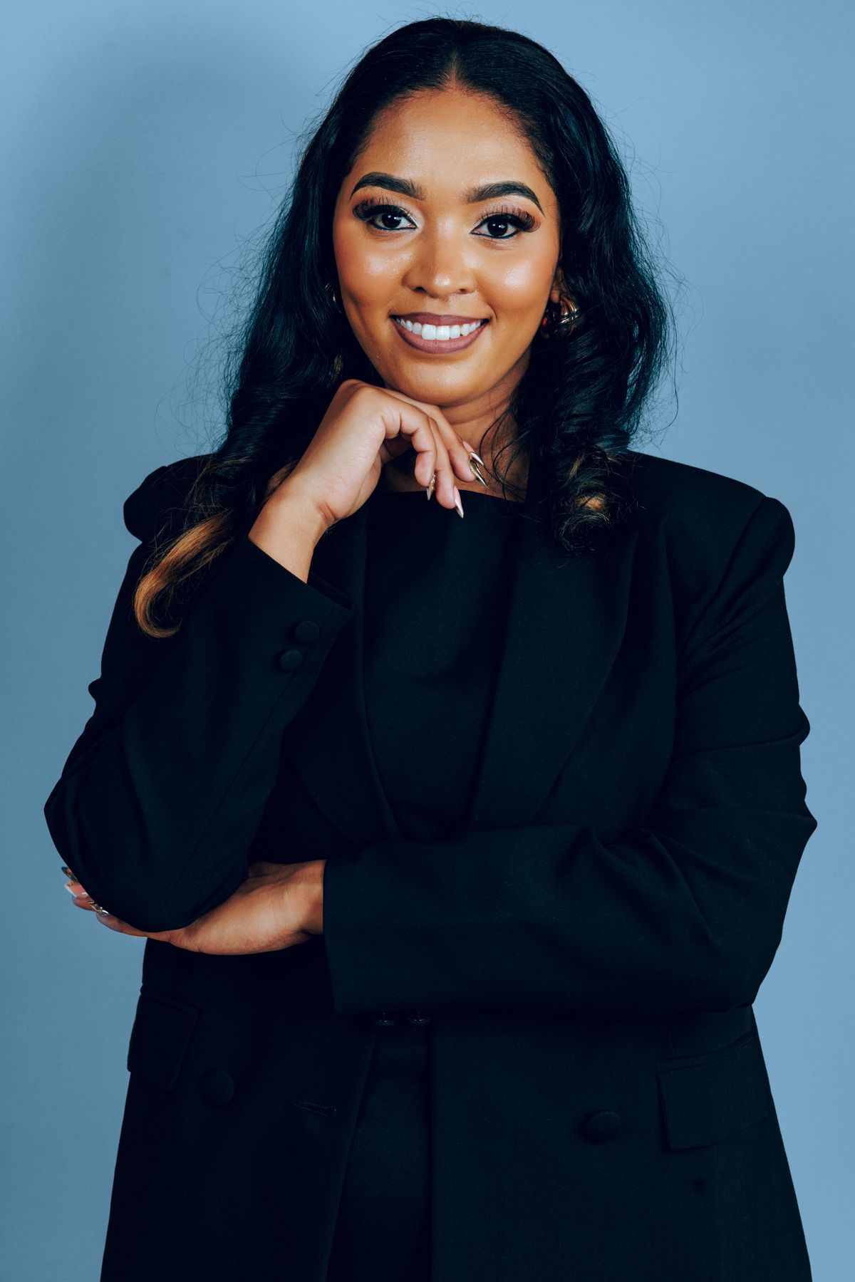 Promotora jovem em look corporativo preto com maquiagem suave e postura profissional