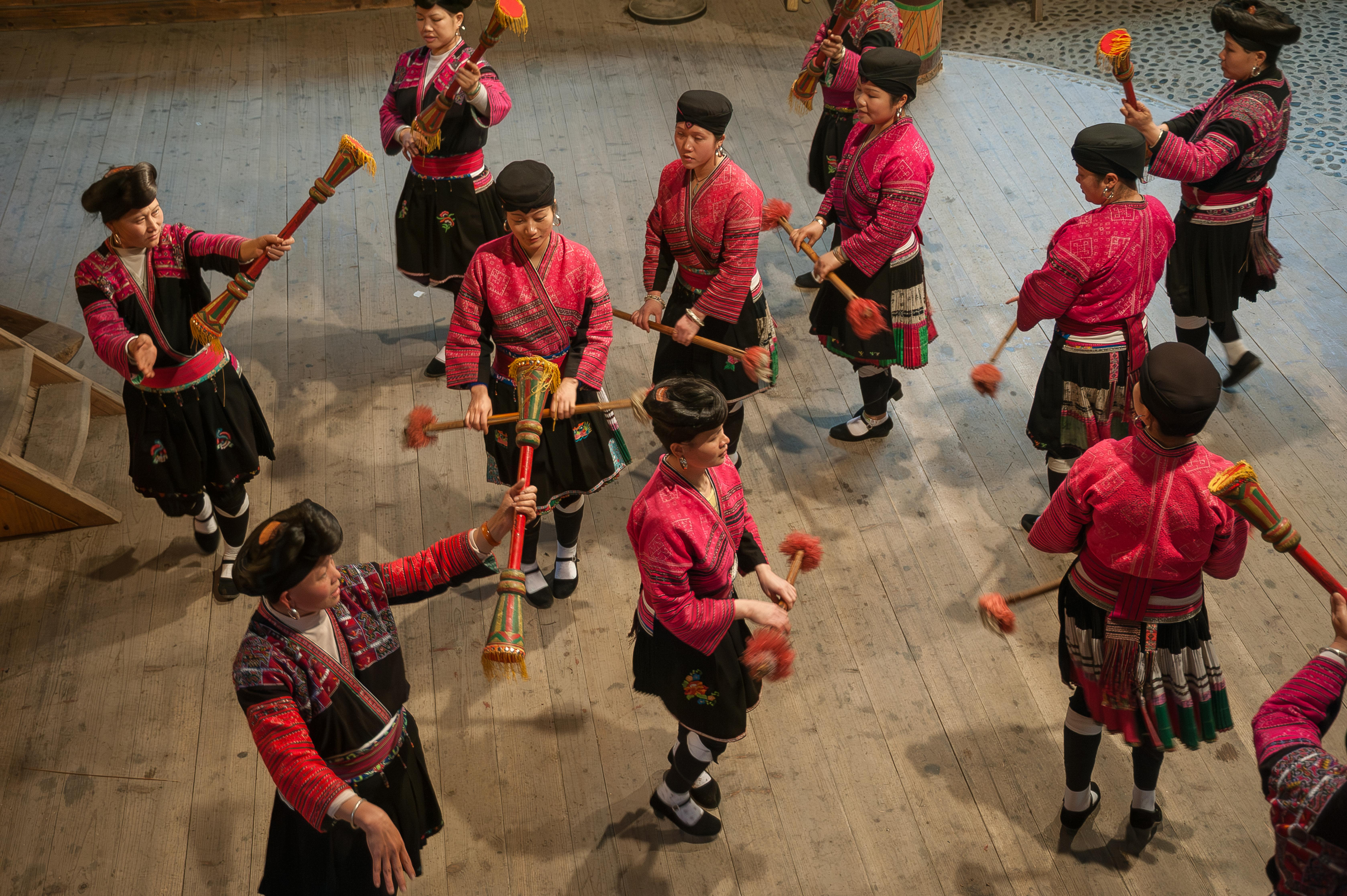 Colorful Yi dancers perform traditional dance in Guilin, Guangxi, showcasing vibrant costumes and cultural heritage.