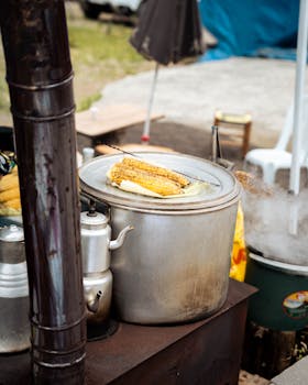 Street food stall with fresh corn being cooked on a traditional outdoor stove.
