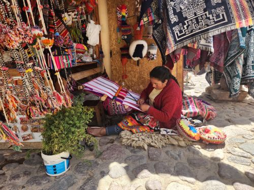 Free Artisan woman weaving traditional textiles in a vibrant Peruvian market. Stock Photo