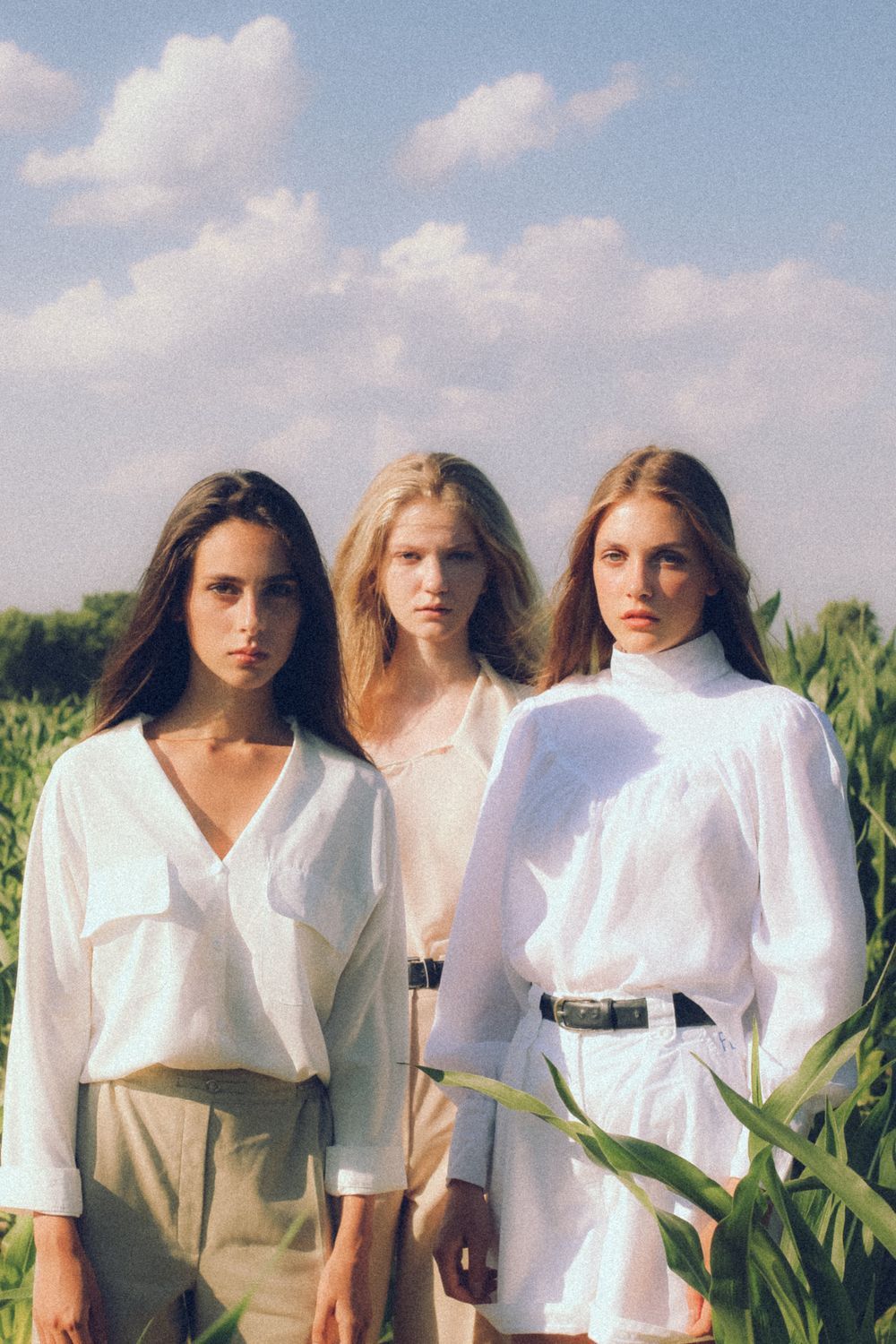 Three Young Women in a Field Under Blue Sky · Free Stock Photo