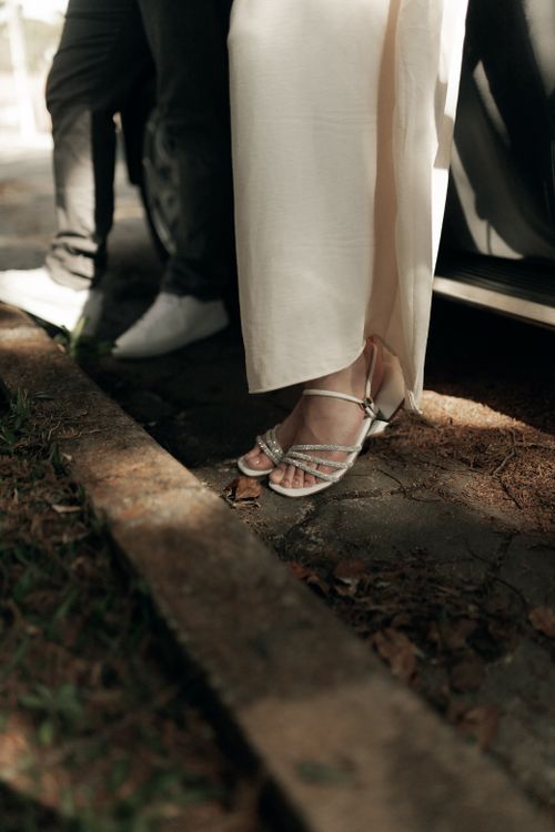 Free Close view of elegant shoes and flowing gown near a car door, with soft lighting. Stock Photo