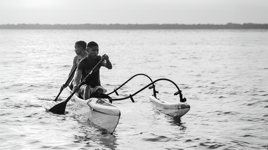 Dois homens canoando no Rio Amazonas, representando a vida tradicional em Belém, Brasil.
