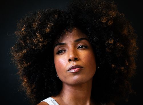 Free Striking portrait of a woman with afro-textured hair, showcasing empowerment and style. Stock Photo