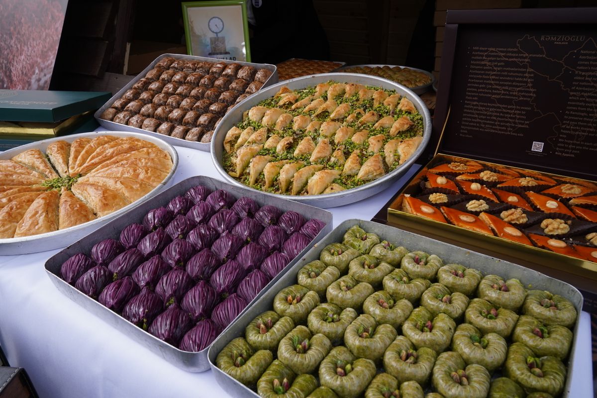 A colorful assortment of Turkish sweets including baklava and lokum placed in metal trays for display.