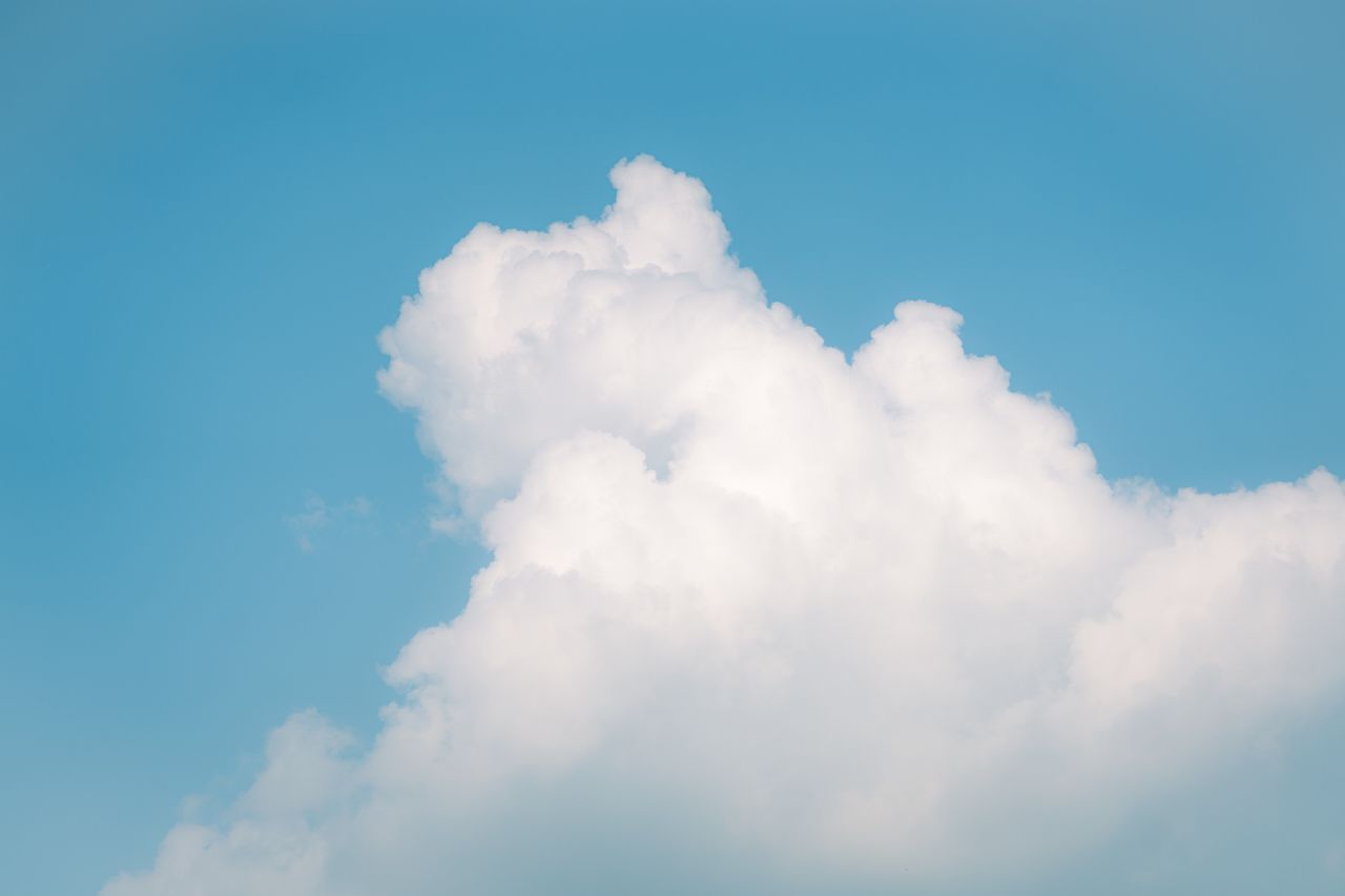 fluffy white clouds in a bright blue sky perfect for background use