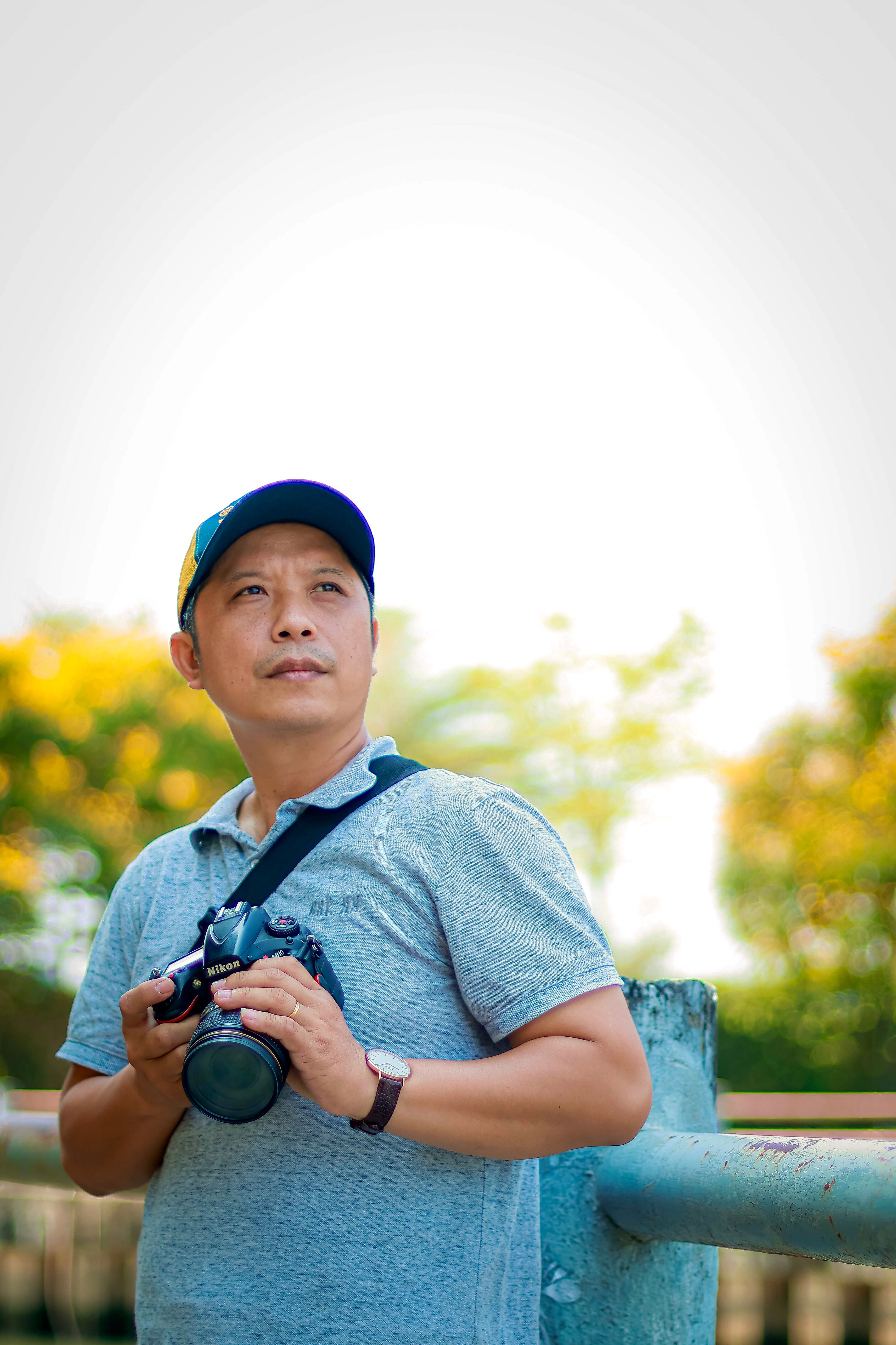 Portrait of an adult male photographer outdoors with a camera.