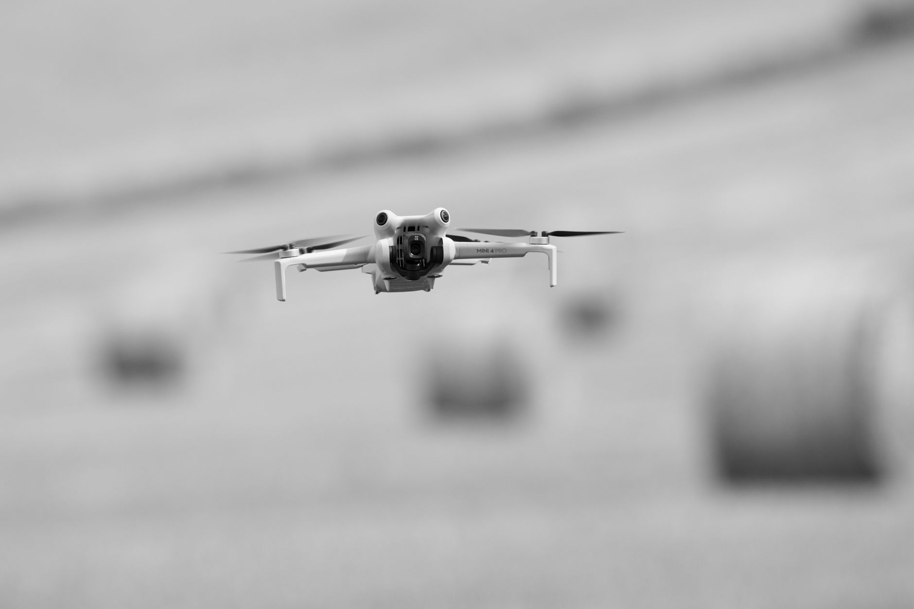 금 시세, 현명하게 알고 투자하는 2025년 최신 가이드 18 Black and white image of a drone flying over rural fields with hay bales in Gränna, Sweden.