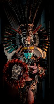 Vibrant portrait of a person in indigenous ceremonial attire with feathered headdress and face paint. - Fotografer Sidoarjo