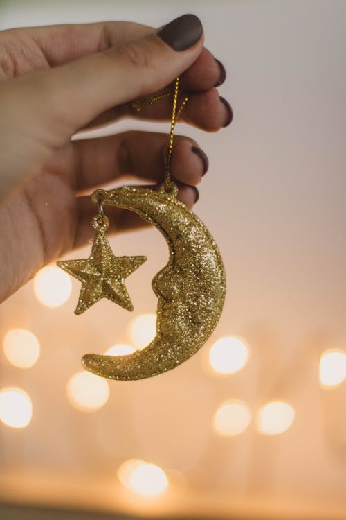 Person Holding Gold Glittered Crescent Moon Ornament