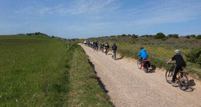 Cyclists enjoy a scenic group ride along a rural countryside path on a sunny day.