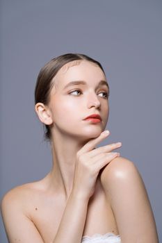 Artistic portrait of a woman against a soft background, showcasing beauty and elegance.