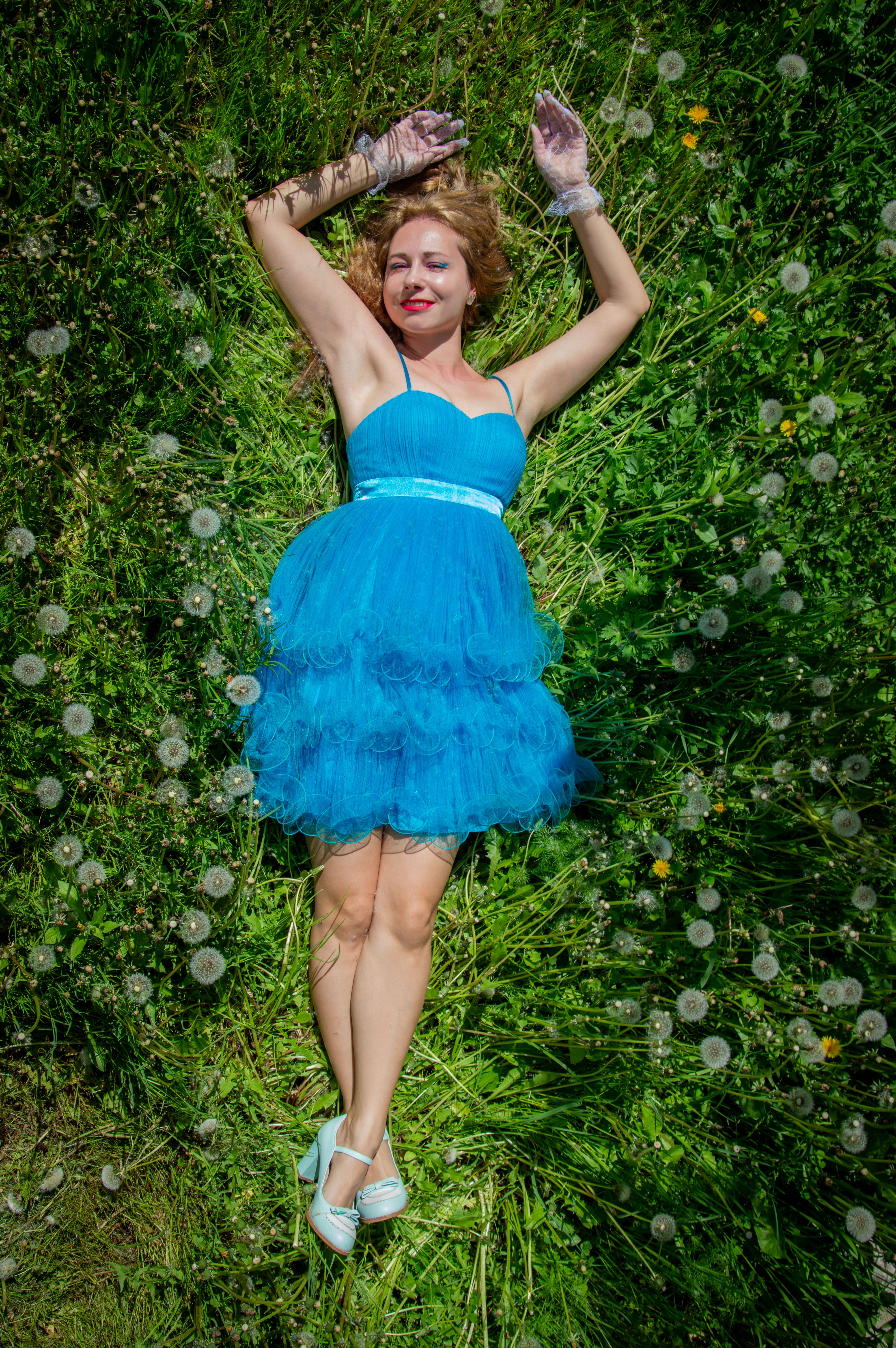 Woman in Blue Dress Lying on Green Grass Outdoors · Free Stock Photo