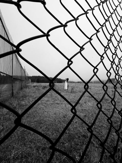 Free Artistic black and white photo of a model posing by a chain link fence in Bolu, Türkiye. Stock Photo