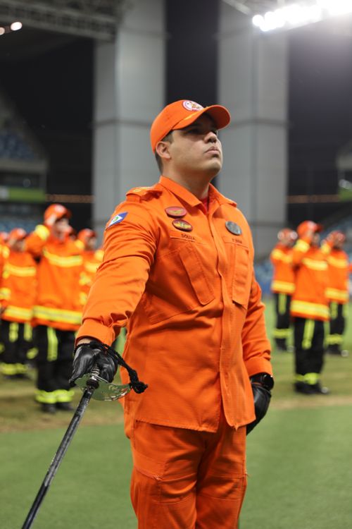 Free Group of firefighters in orange uniforms during a formal ceremony at night. Stock Photo