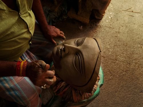 Free Craftsman hand-carving a clay idol in Kolkata's Kumartuli district, highlighting traditional techniques. Stock Photo