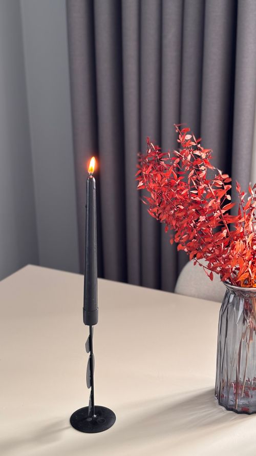 Free Stylish table setup featuring a lit candle and vibrant red foliage in a modern vase. Stock Photo
