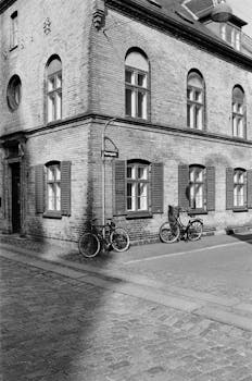 An atmospheric black and white photo of a vintage street corner with bicycles in Copenhagen, Denmark.