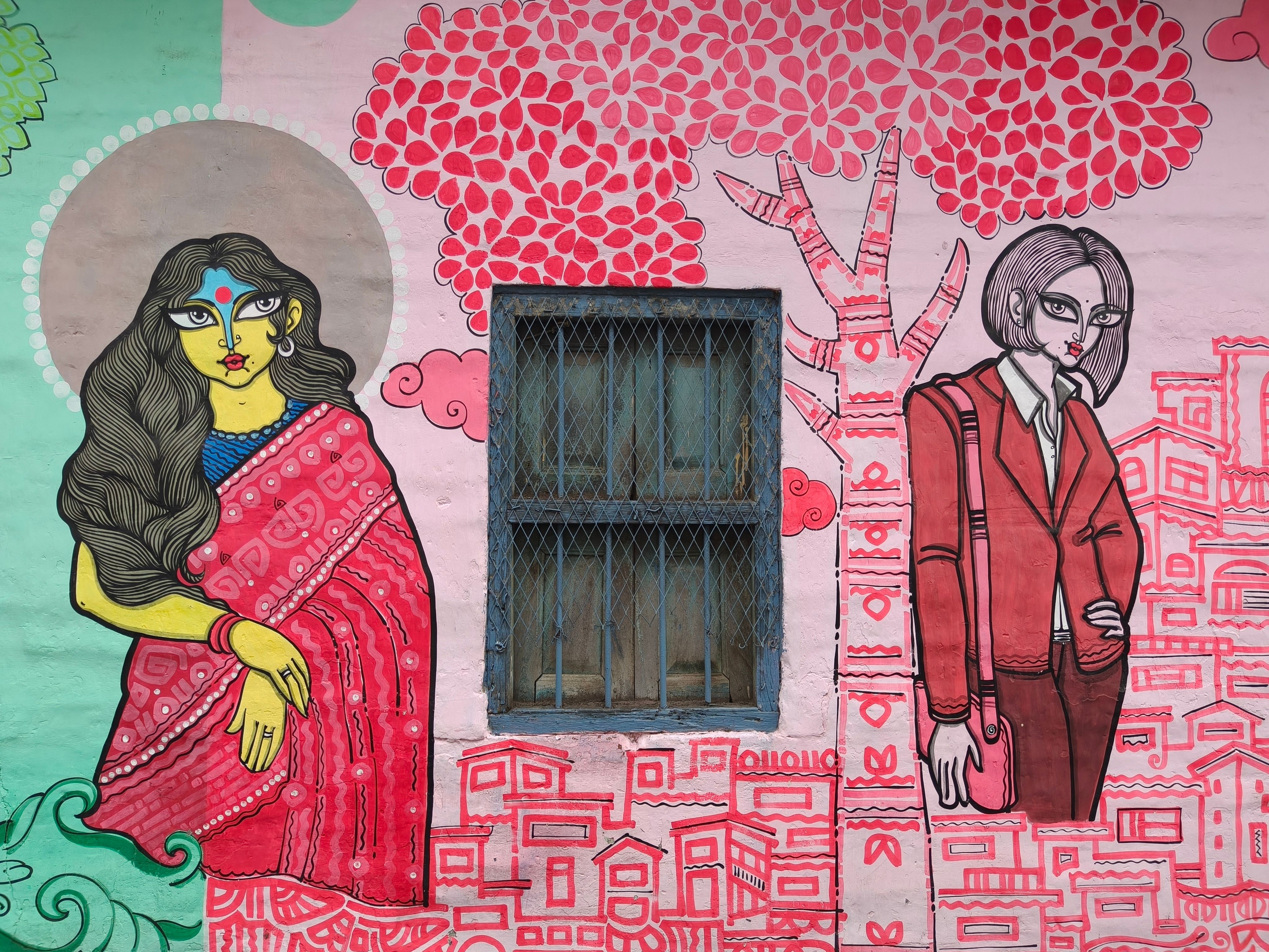 Colorful street art depicting characters on a wall in Kolkata, India.
