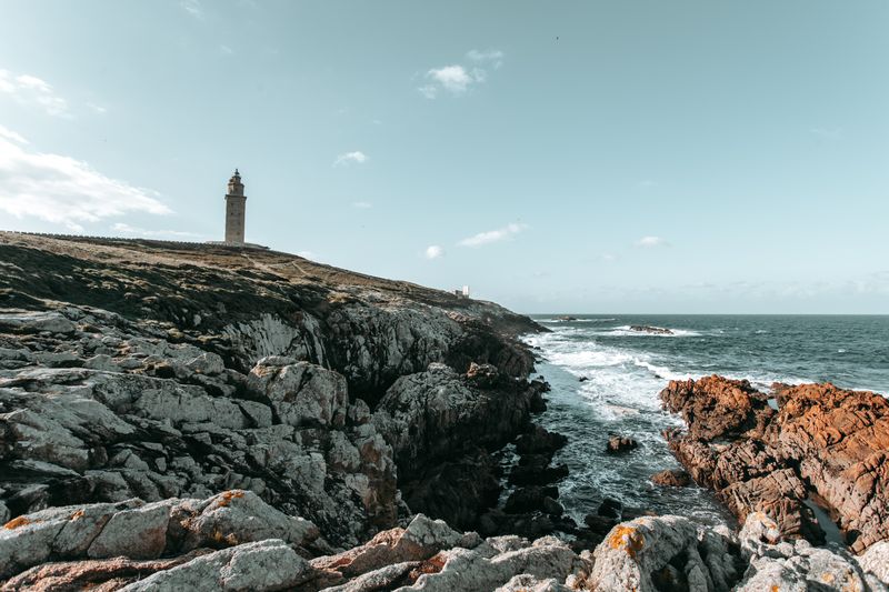 Lighthouse above a rugged Atlantic coastline, photo by Ave Calvar Martinez on Pexels