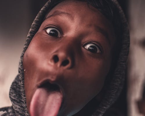 Boy in Gray Hoodie Doing With Tongue Out