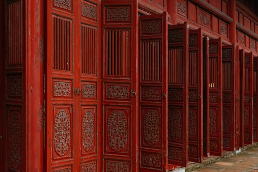 Detailed shot of traditional carved wooden doors in Hue, Vietnam, showcasing cultural heritage.