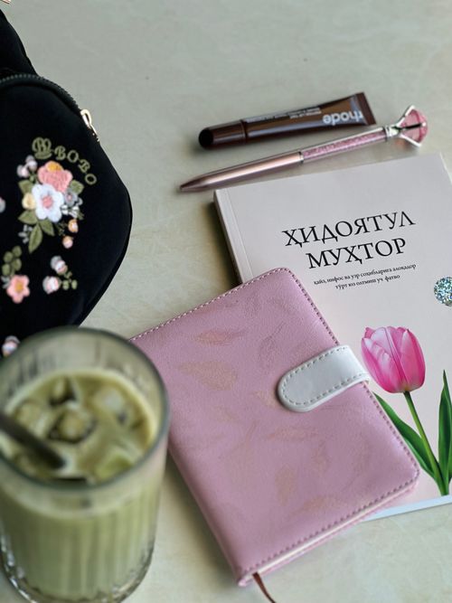 Free Flat lay with notebook, iced coffee, and book with Cyrillic text, conveying a cozy workspace vibe. Stock Photo