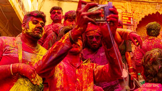 Group of people celebrating Holi with vibrant color powder, capturing the joyous moment.