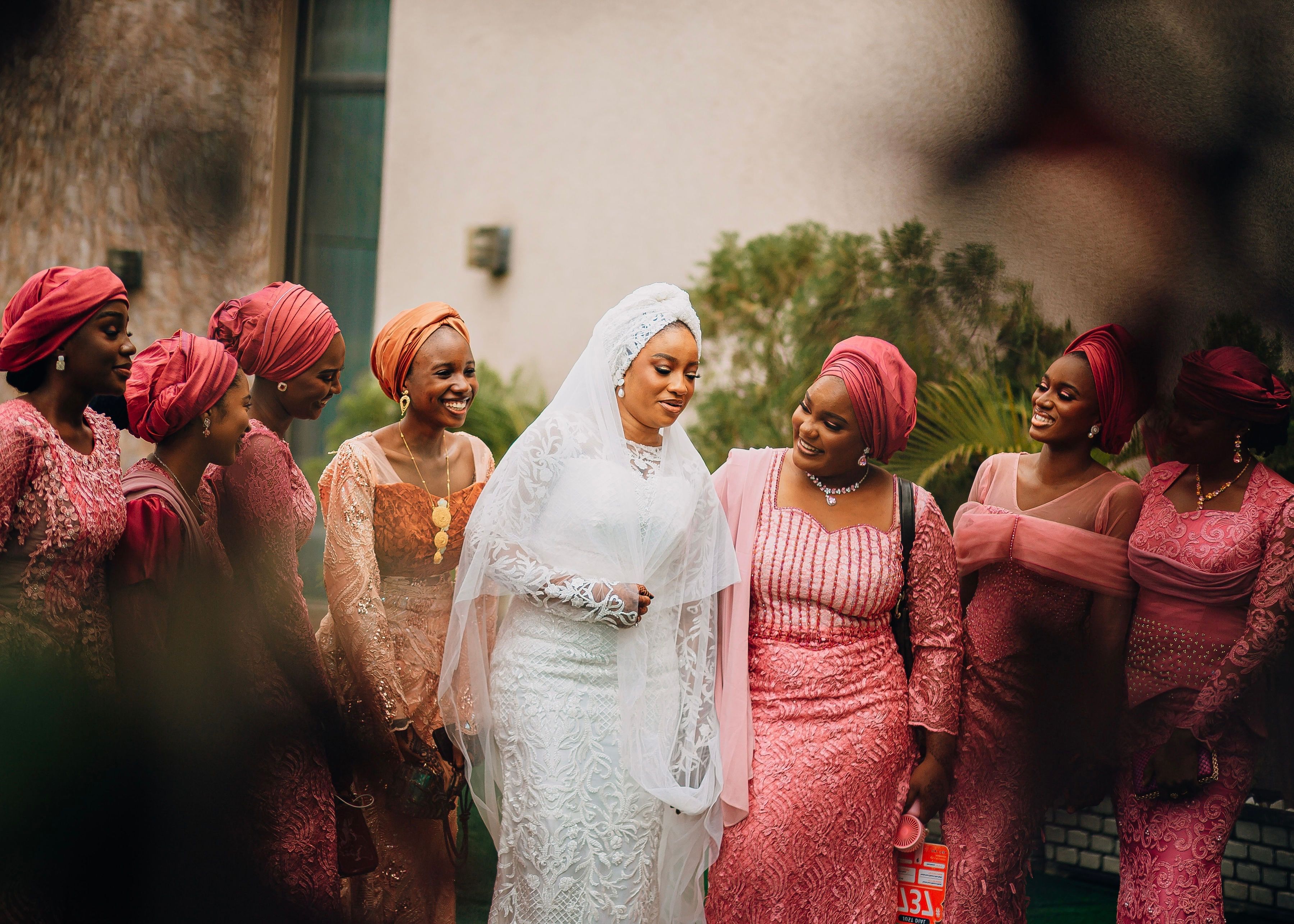 Bride with bridesmaids in colorful outfits, captured outdoors.
