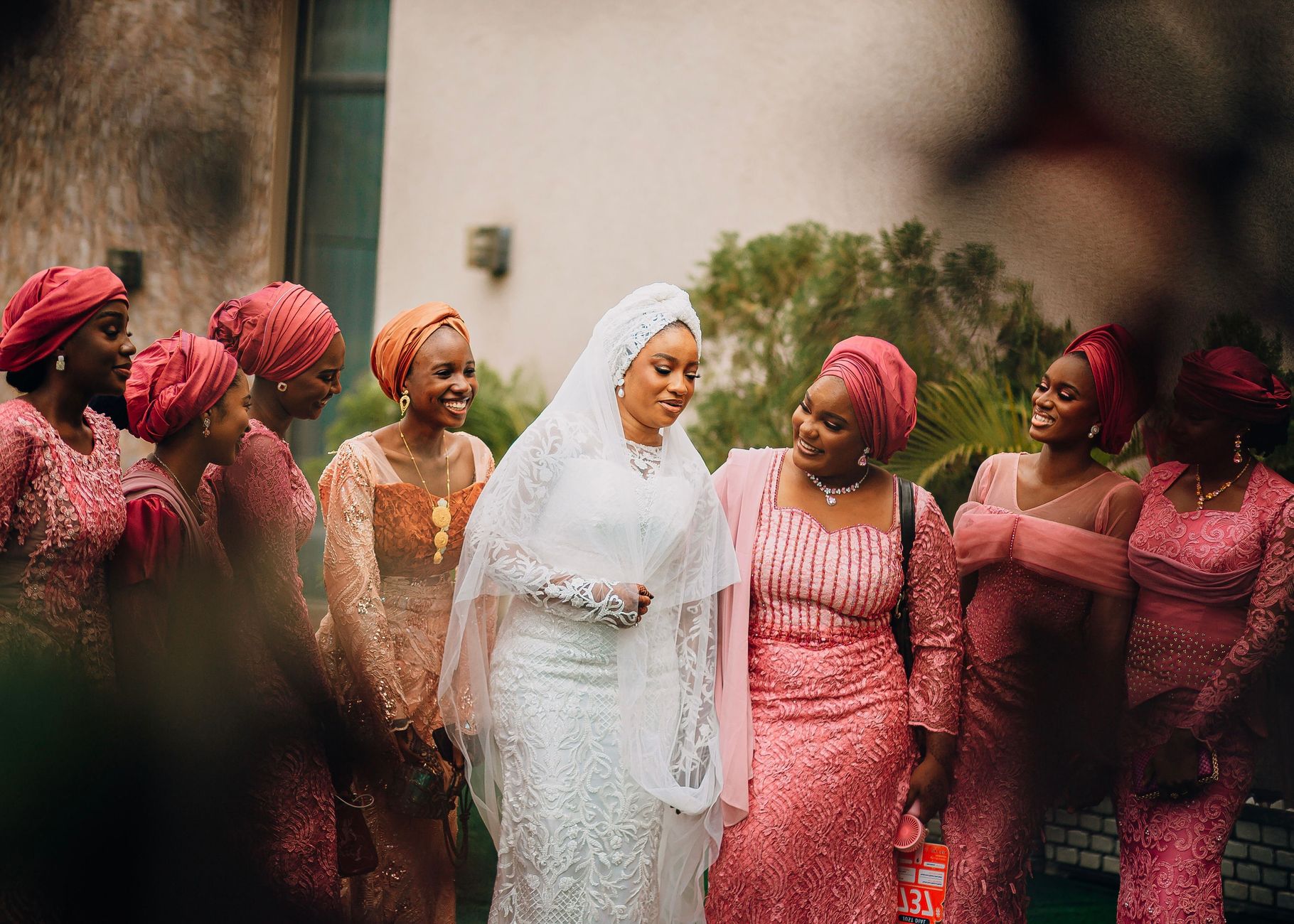 Bride with bridesmaids in colorful outfits, captured outdoors.