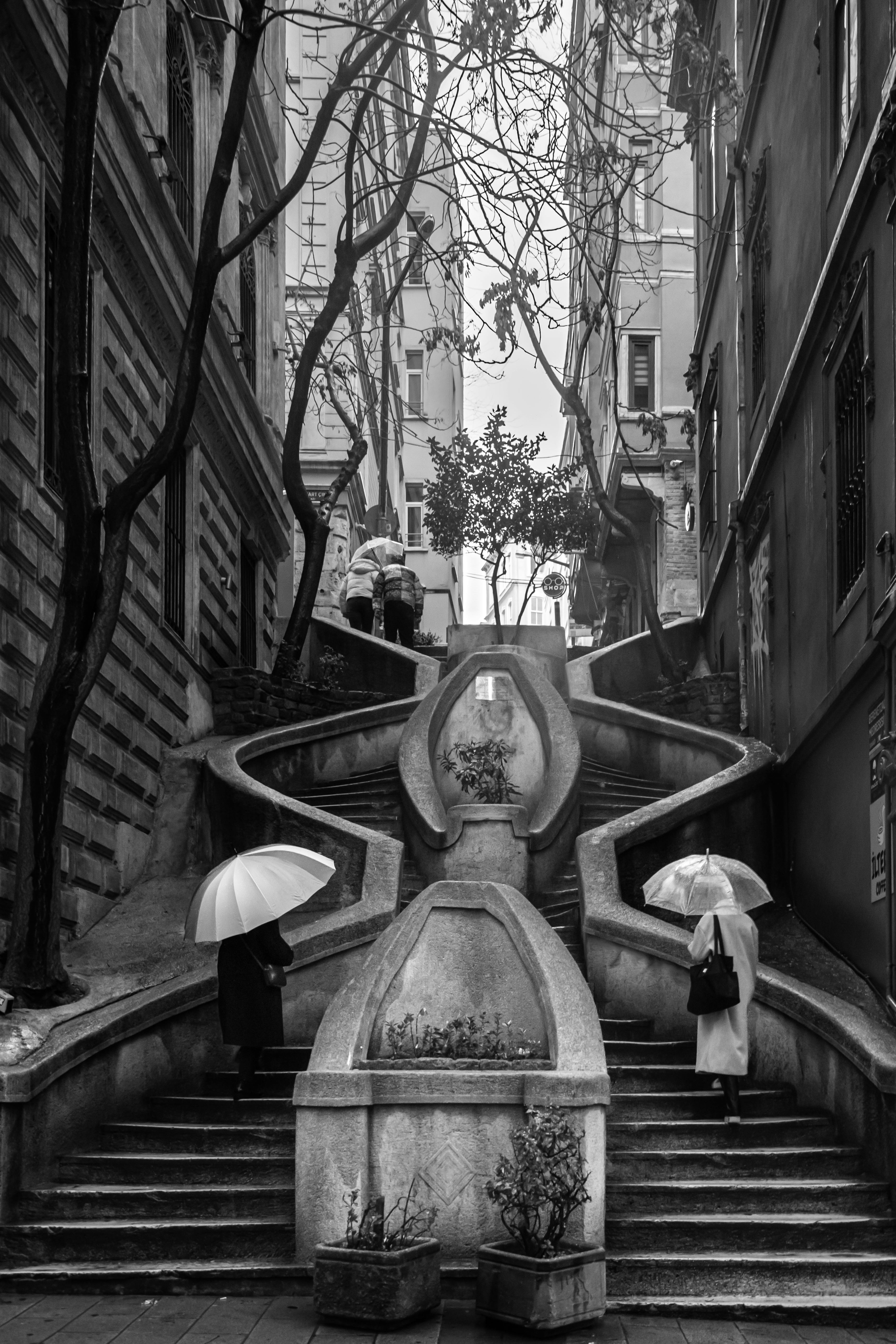 Monochrome photo of umbrella users on famous Istanbul staircase, Türkiye.