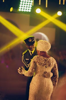 An ornate dance scene with a couple in formal attire, highlighted by colorful stage lighting.