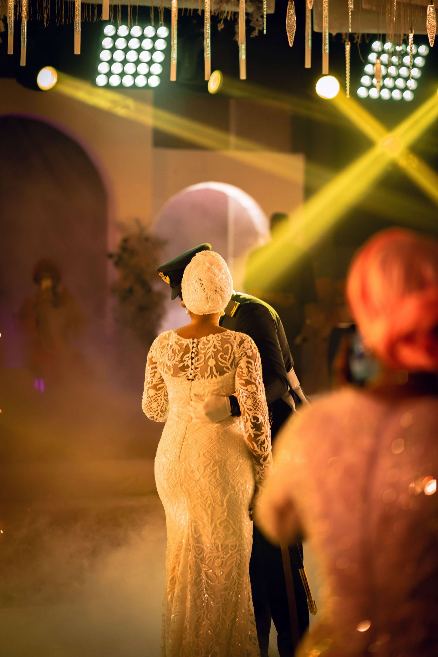 Wedding couple dancing under colorful lights