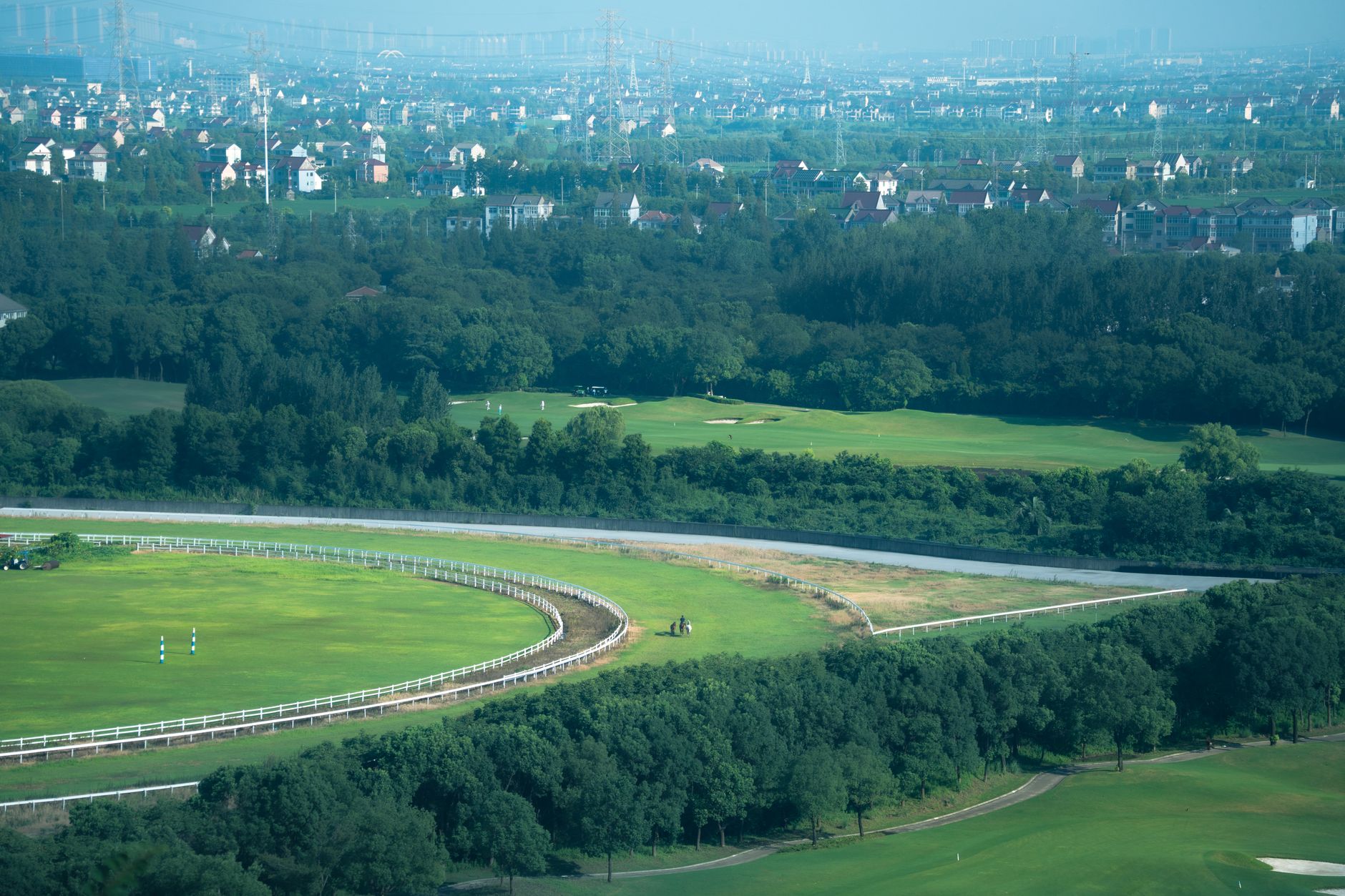英國賽馬場晨霧籠罩草地跑道,騎師帶馬熱身