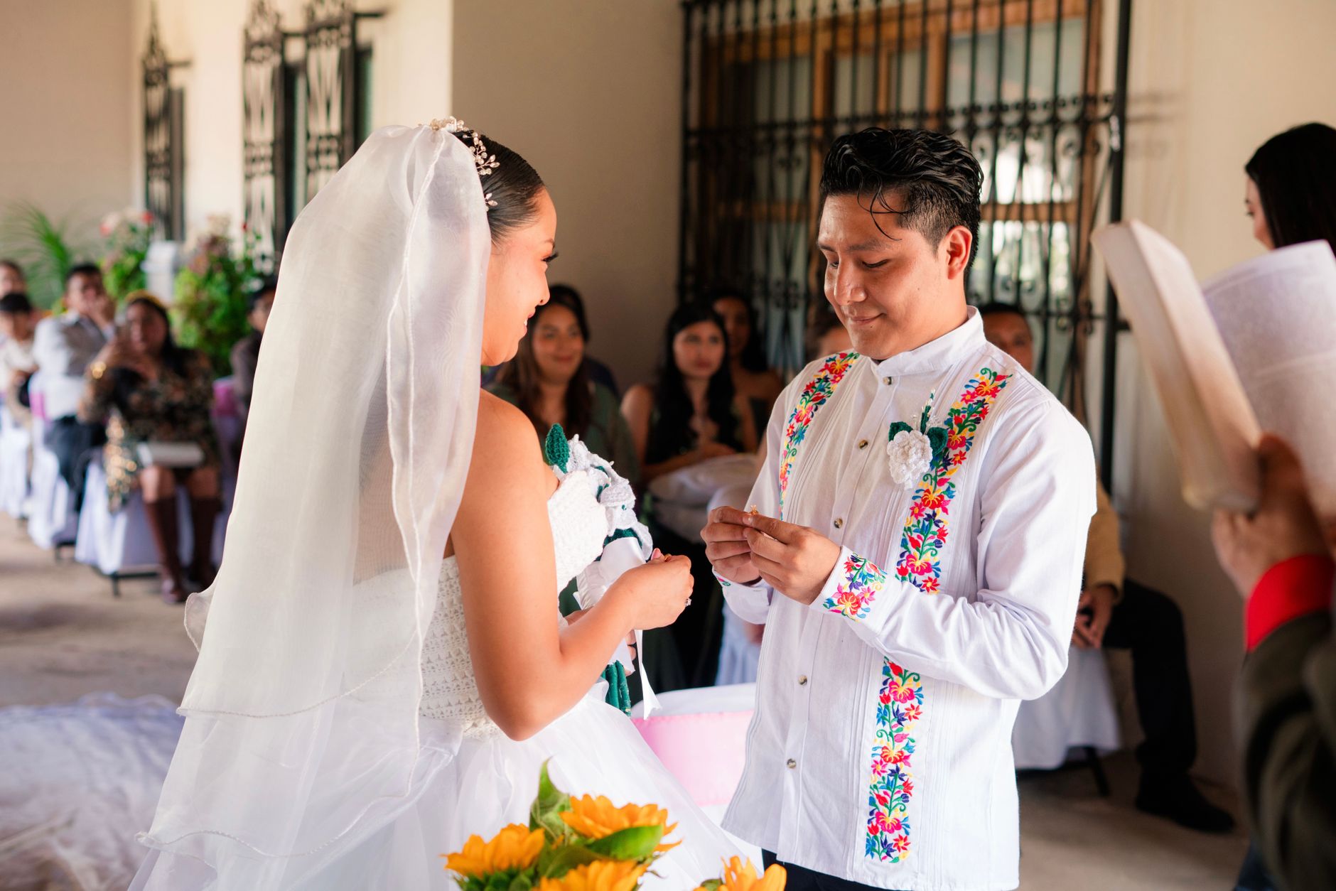 luxury wedding entertainment Egypt — Bride and groom exchange rings in colorful, cultural wedding setting.