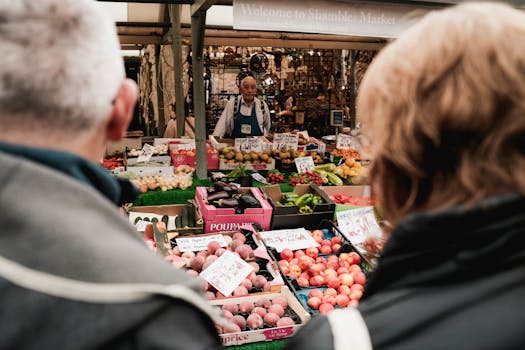 Crowds explore the colorful stalls at Shambles Market, York, bustling with fresh produce and vibrant life.