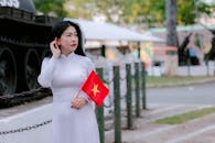 Vietnamese Woman Holding National Flag Outdoors