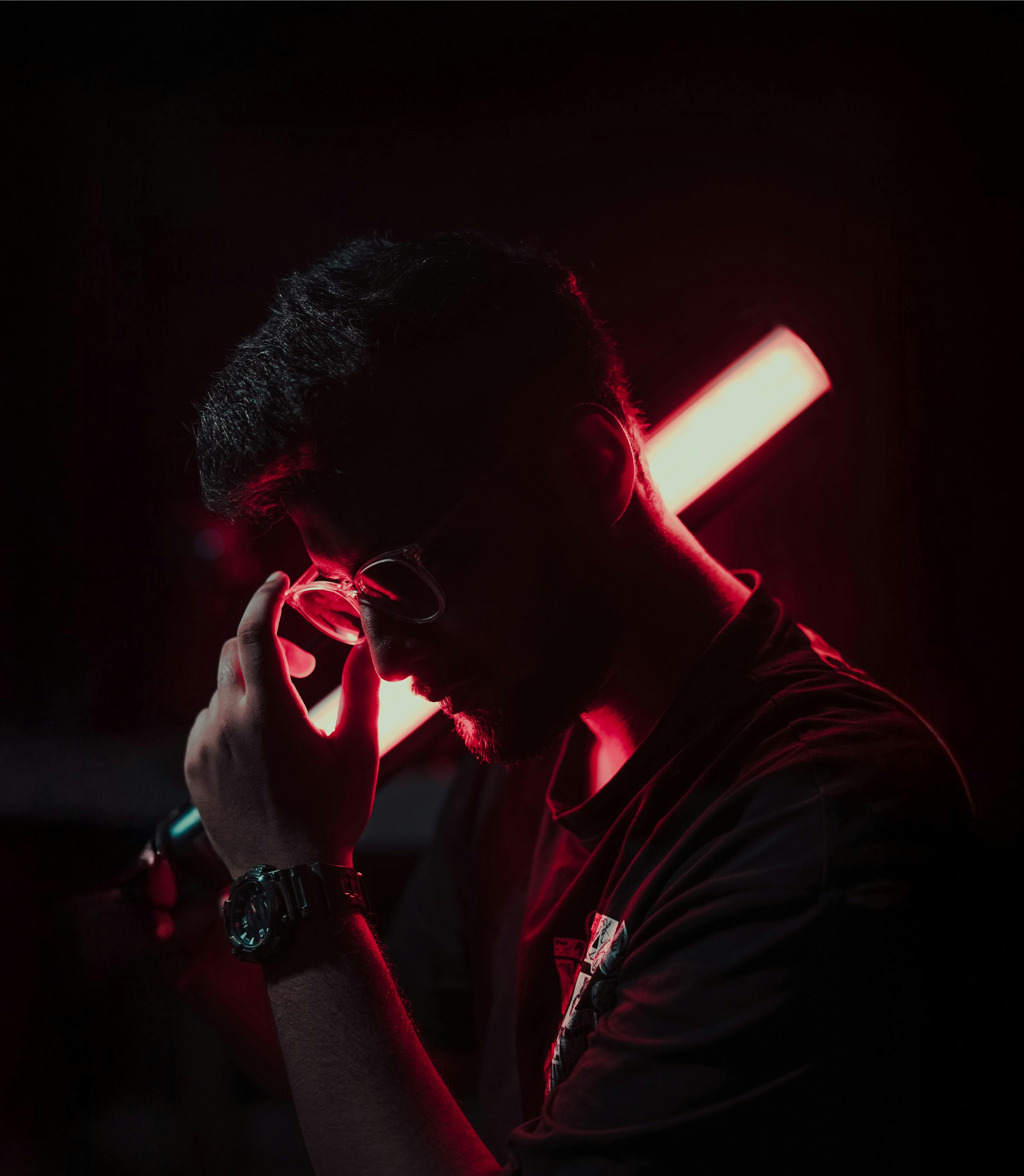 Silhouette of a man posing with red neon lighting, creating a moody, cinematic effect.