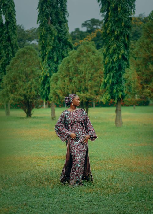 Free Serene image of a woman in traditional attire posing gracefully in a verdant park. Stock Photo