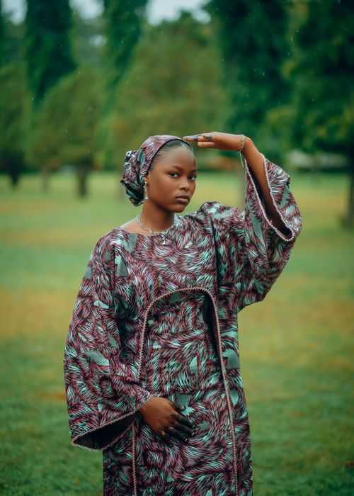 Free A woman in vibrant traditional African dress standing outdoors, showcasing a blend of culture and style. Stock Photo